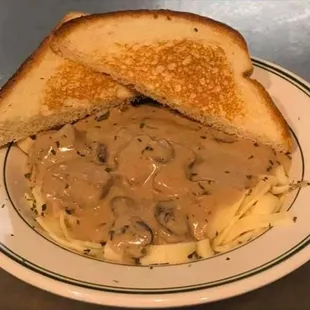 a plate of food with a sandwich and mushroom gravy