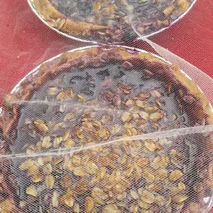 two pies covered in plastic