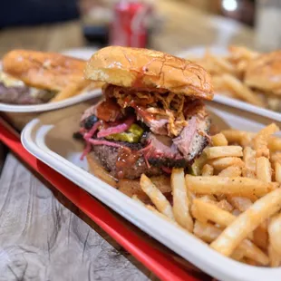 Smoke-stack burger - half-pound brisket burger, tallow-brush bun, served with a side of fries.