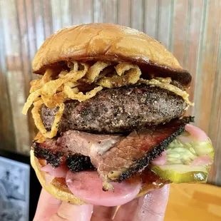 The "Smokestack Burger": half-pound brisket patty, smoked brisket slices, onion strings, homemade pickles on a garlic tallow-basted bun