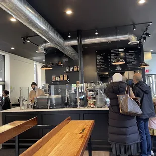 a man and a woman standing in a coffee shop