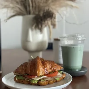 a croissant sandwich with lettuce and tomato