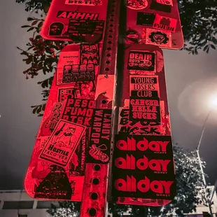 a red street sign with stickers on it