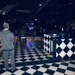 a man standing in front of a black and white checkered floor