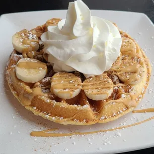 a waffle topped with bananas and whipped cream