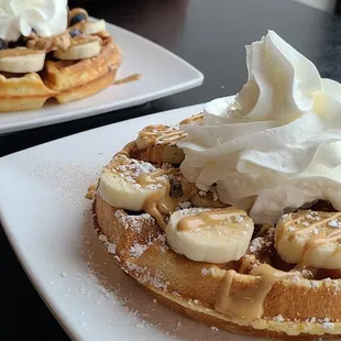 two waffles topped with whipped cream and bananas