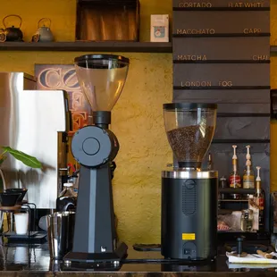 two coffee grinders on a counter