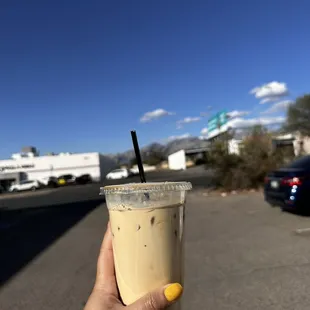 a hand holding a cup of iced coffee