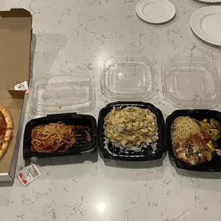 a variety of pizzas and takeout containers