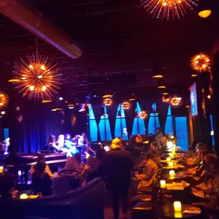 a crowd of people sitting at tables in a dimly lit room