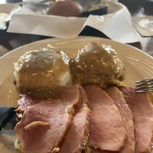 Glazed ham, dressing, mashed potatoes with gravy and rolls.