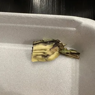 a piece of broccoli in a styrofoam container