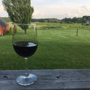 a glass of red wine on a deck