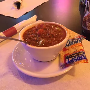 a bowl of chili and crackers