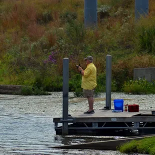Guy looks like he's got a fish on (by boat ramp)
