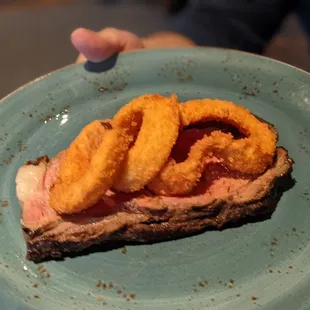 a hand holding a plate of food