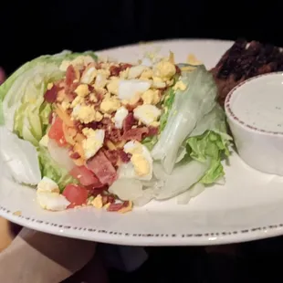 a plate of salad with eggs and bacon