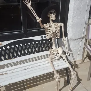 a skeleton sitting on a bench
