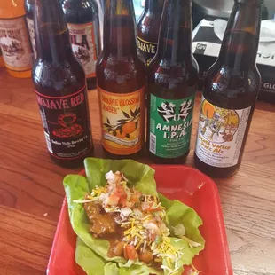 a plate of food and bottles of beer