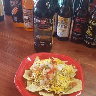 a plate of nachos and bottles of beer