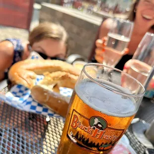 a woman sitting at a table with a glass of beer