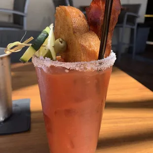 a bloody drink with bacon and cucumber