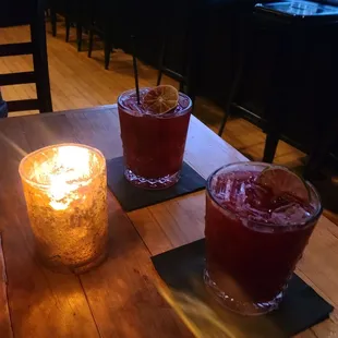 a table with two glasses and a candle