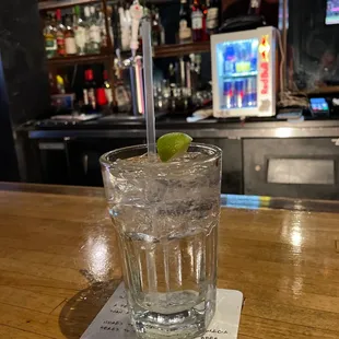 a glass of water with a lime in it