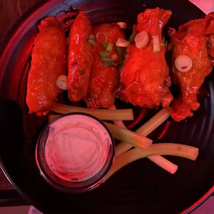 a plate of chicken wings with dipping sauce