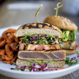 Wicked Tuna Burger. 5oz Seared Ahi, Coconut Amino, Asian Coleslaw, Tomato, Avocado Dressing. Served with Roasted Sweet Potato Fries