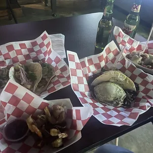 Left to right- bacon wrapped shrimp app, blackened shrimp tacos, trashcan tacos, Cajun tots.