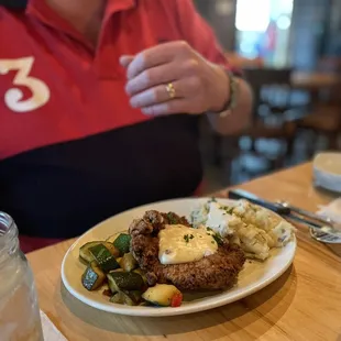 a woman sitting at a table with a plate of food