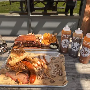 Bottom plate. Texas Style Brisket, jalapeño smoked sausage, pulled Pork, smoked Turkey, pork skins. Top plate. Full rack and fries