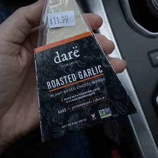 a hand holding a bag of roasted garlic