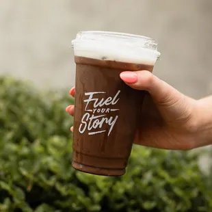 a hand holding a coffee cup