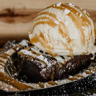a chocolate brownie topped with ice cream