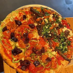 Half #9 (Fresh Tomato, Green Pepper and Kalmata Olives Pizza), half #11 (Persian Beef with Tomato, Feta, and Harissa)