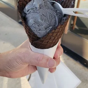 a hand holding a cone of ice cream