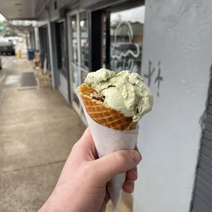 a hand holding a cone of ice cream
