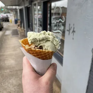 a hand holding a cone of ice cream