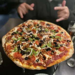 a man sitting at a table with a pizza
