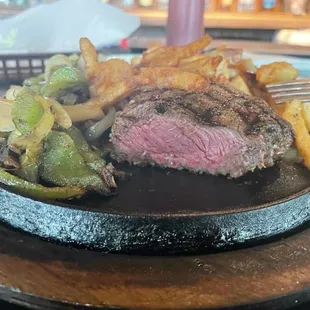 steak and fries on a black plate