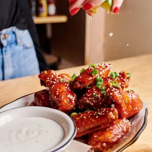 a person sprinkling sauce