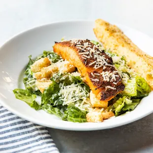 a plate of salad with a piece of bread