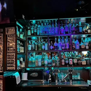 a bar with liquor bottles and a television