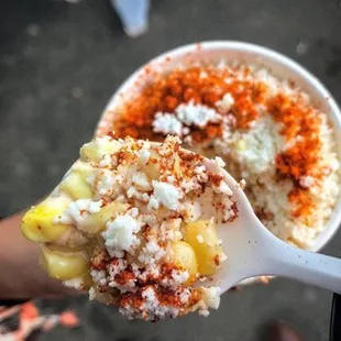 a person holding a spoon full of food