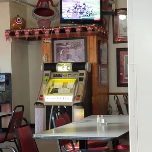 a table and chairs with a television in the background