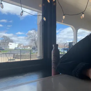 a person sitting at a table with a bottle of beer