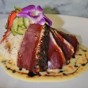 a plate of food with rice, meat, and vegetables