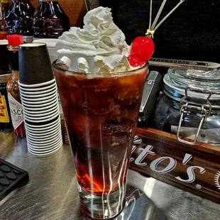 a cold drink with whipped cream and a cherry